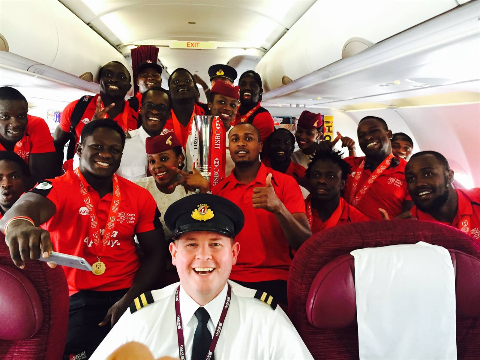 Airline crew posing together inside an aircraft